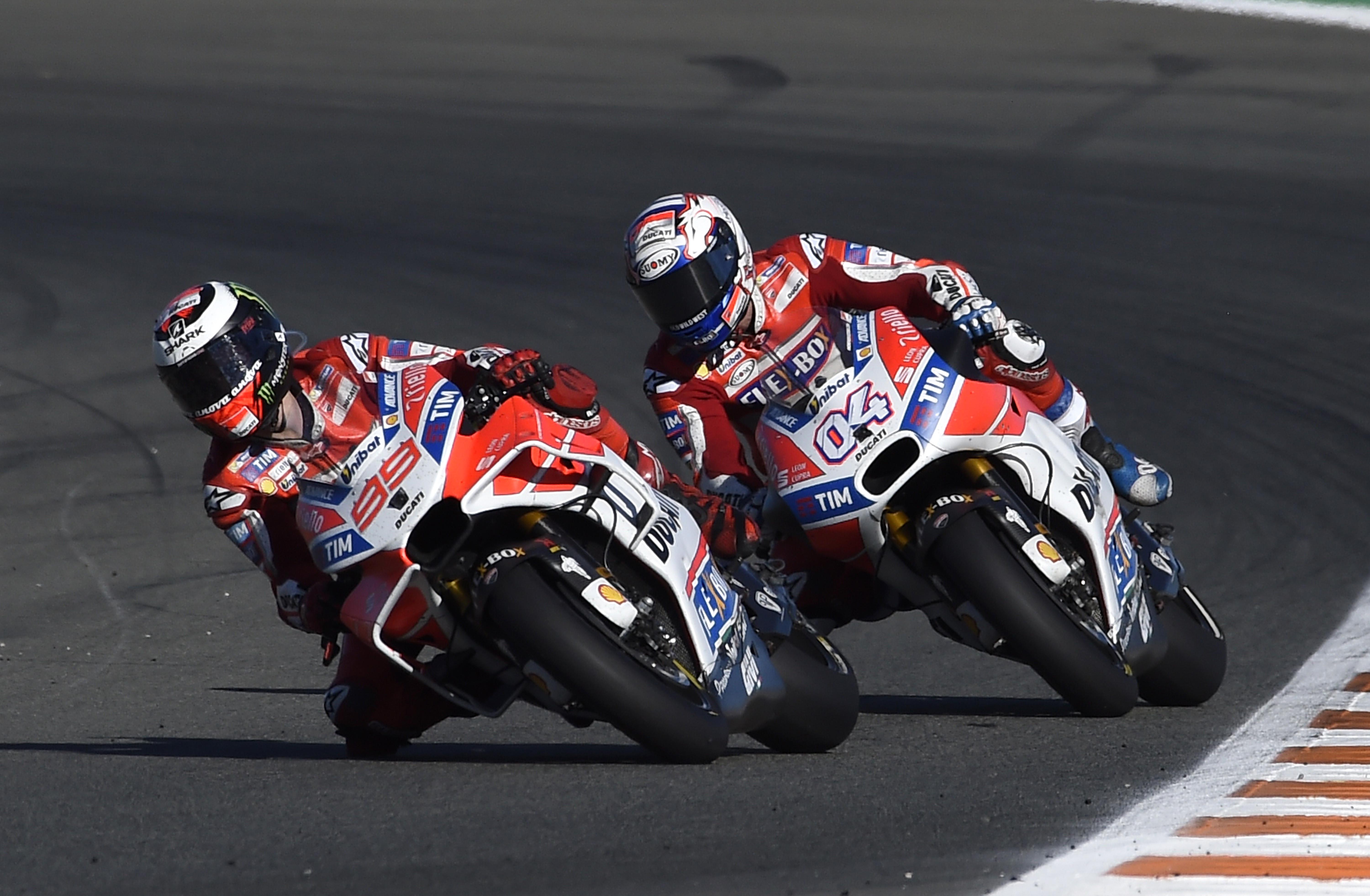 Perjuangan pembalap Ducati, Andrea Dovizioso saat menempel rekan setimnya, Jorge Lorenzo, pada MotoGP Valencia 2017 di Sirkuit Ricardo Tormo. (JOSE JORDAN / AFP)