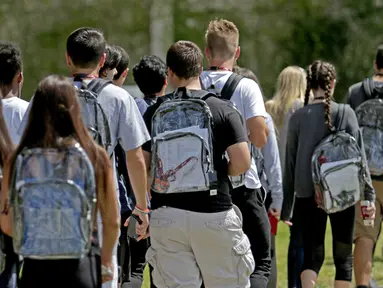 Siswa SMA Marjory Stoneman Douglas menggunakan ransel transparan di Parkland, Florida, Senin (2/4). Penggunaan tas itu sebagai salah satu upaya mencegah terjadinya kembali kasus penembakan brutal di sekolah. (John McCall/South Florida Sun-Sentinel via AP)