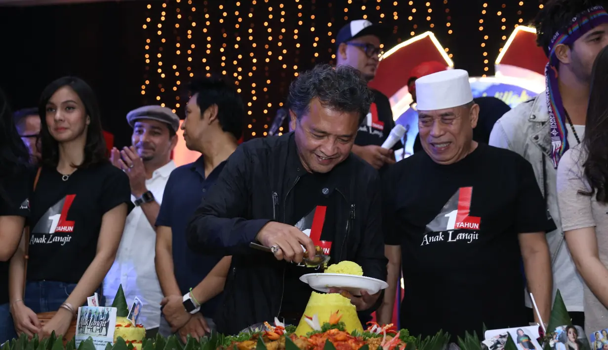 Acara syukuran ulang tahun itu juga ditandai dengan potong tumpeng. Terlihat dari para pemain dan kru kompak dengan mengenakan kaos hitam yang bertuliskan Anak Langit. (Nurwahyunan/Bintang.com)