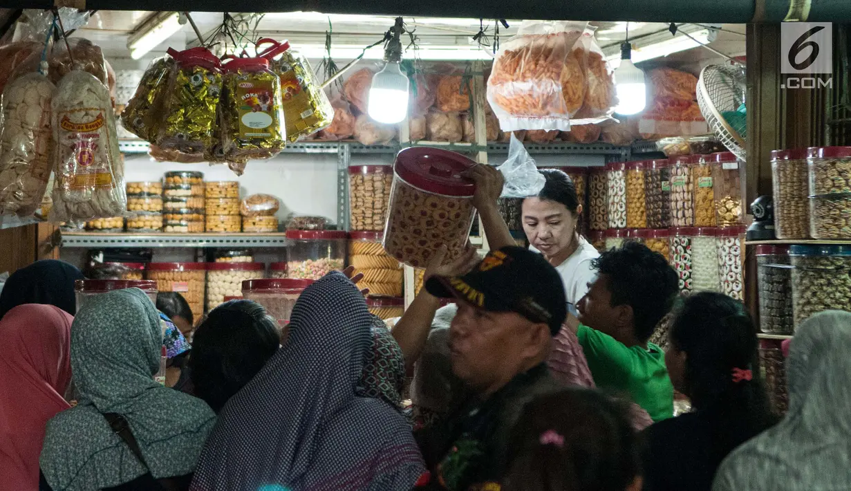 Calon pembeli mengantre untuk membeli kue kering di toko kue Pasar Jatinegara, Jakarta, Selasa (14/6). Harga kue kering yang dijual di tempat tersebut berkisar antara Rp 25 ribu - Rp 160 ribu per kg. (Liputan6.com/Gempur M Surya)
