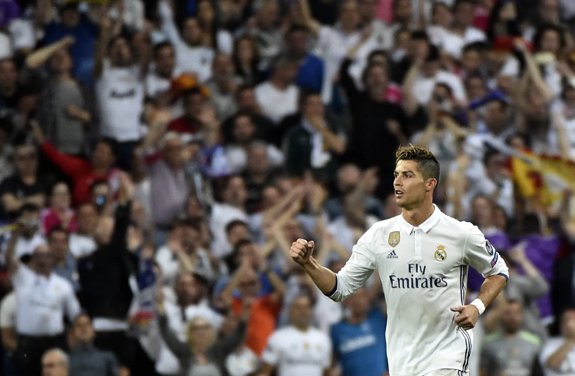 Cristiano Ronaldo merayakan gol bersama pendukung yang memadati Estadio Santiago Bernabeu. (AFP/Gerard Julien)