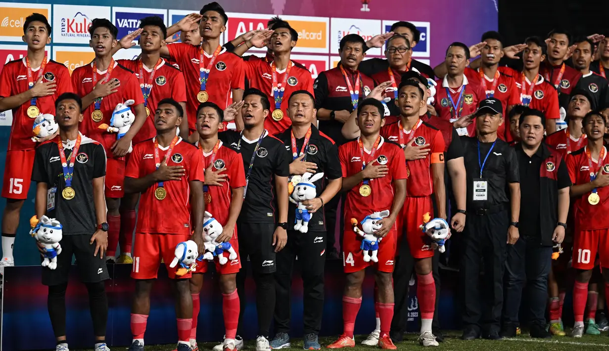 Timnas Indonesia menyanyikan lagu kebangsaan Indonesia Raya di podium saat merayakan kemenangan medali emas dalam pertandingan final sepak bola putra melawan Thailand dalam SEA Games ke-32 di Phnom Penh pada 16 Mei 2023. (MOHD RASFAN/AFP)