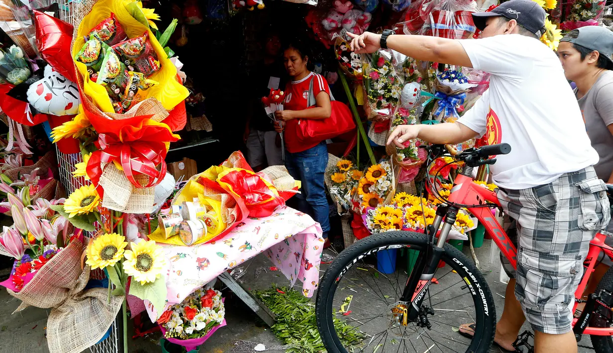 Seorang pembeli melihat bunga yang dijajakan di sebuah pasar bunga sehari sebelum Valentine Day di Manila, Filipina, Rabu (13/2). Sudah tradisi di seluruh dunia, setiap hari valentine identik dengan pemberian bunga atau coklat. (AP Photo/Bullit Marquez)