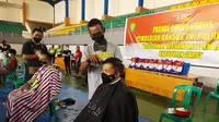 Selain warga, Kapolres Garut AKBP Wirdhanto Hadicaksono  serta Dandim 0611 Garut Letkol Deni Iskandar, ikut langsung menjadi peserta potong rambut gratis tersebut. (Liputan6.com/Jayadi Supriadin)