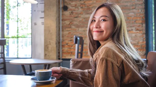 tenang kalem dewasa minum kopi di kafe baju coklat