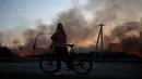 Seorang warga setempat melihat gudang yang terbakar setelah serangan drone Rusia di wilayah Kyiv, Ukraina, pada 20 September 2026, di tengah invasi Rusia ke Ukraina.(Genya SAVILOV / AFP)