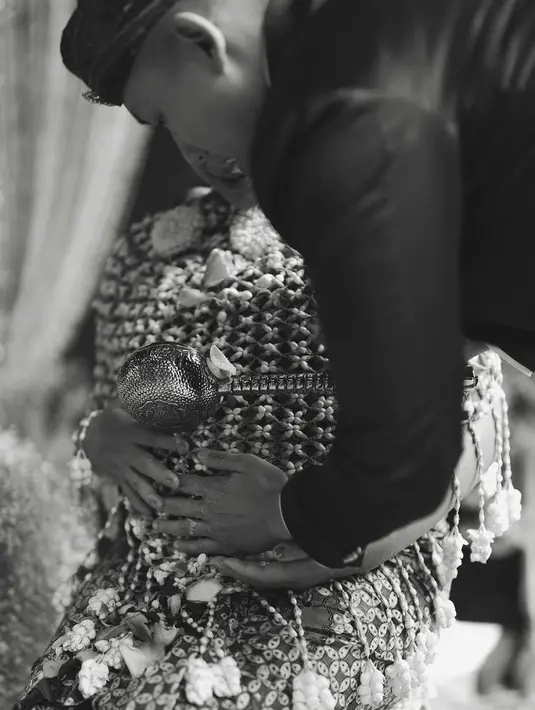 Angel juga lengkap mengenakan ronce melati yang membalut tubuhnya. Sambil disiramkan air kembang pada perutnya oleh sang suami yang mengenakan beskap. [@angelpieters]