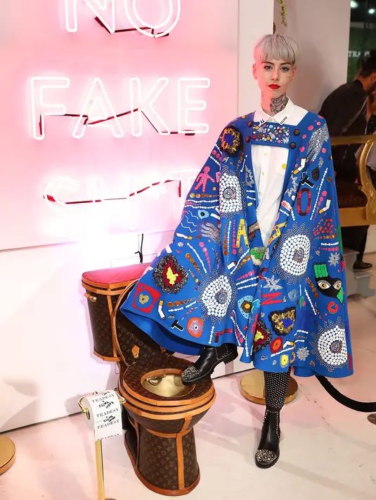 Seniman Illma Gore berpose dengan karya seninya, sebuah toilet emas berlapis kulit tas Louis Vuitton yang dipamerkan dalam sebuah showroom di California, Los Angeles, 8 November 2017. (Joe Scarnici/Getty Images for Tradesy/AFP)