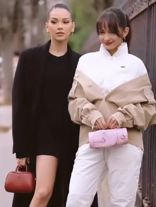 <p>Jaket tersebut serasi dengan celana panjang model training. Dipadukan sneaker hitam putih, sambil membawa mini bag pink. [@enzystoria]</p>