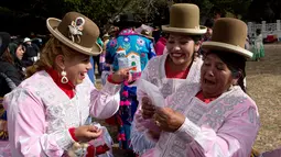 Sejumlah penari wanita berbincang sebelum acara karnaval Anata Andina (Andean karnaval) di Caquiaviri, Bolivia, Selasa (17/1). Ratusan kelompok etnis dari Provinsi Caquiaviri berpartisipasi dalam karnaval ini. (AP Photo/Juan Karita)