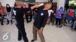 Peserta penyandang cacat melihat aksi bela diri praktis di YPAC, Jakarta, Sabtu (6/8). Bela diri Praktis ini di harapkan mampu untuk menjaga diri khususnya penyandang cacat dari segala bentuk serangan dan ancaman kejahatan. (Liputan6.com/Johan Tallo)