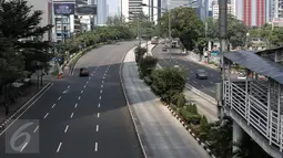 Pengendara melintasi jalan protokol yang lengang di kawasan MH Thamrin, Jakarta, Selasa (6/7). Hampir semua jalan di Ibu Kota lengang saat sebagian besar warga mudik untuk merayakan Lebaran di kampung halaman. (Liputan6.com/Faizal Fanani)