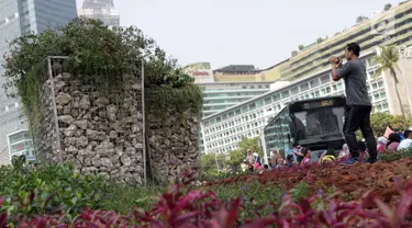 Salah satu warga memotret Instalasi Gabion saat CFD di kawasan Bundaran Hotel Indonesia, Jakarta, Minggu (25/8/2019). Pengadaan Instalasi Gabion ini menggunakan Anggaran Pendapatan dan Belanja Daerah (APBD) Dinas Kehutanan DKI sebesar Rp 150 juta. (Liputan6.com/Helmi Fithriansyah)