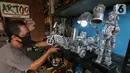 Animator Toto Sihono, merapikan produk berupa pajangan dari limbah komponen elektronik di Galeri Artos Griya Asri Pamulang, Tangerang Selatan, Rabu (16/8/2020). Produk dari limbah elektronik dibentuk menjadi robot, pajangan lampu, mobil-mobilan hingga maket perkotaan. (Liputan6.com/Fery Pradolo)