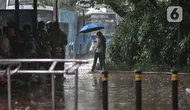 Warga menggunakan payung saat hujan mengguyur kawasan Monas, Jakarta Pusat, Kamis (5/1/2023). Warga diharapkan waspada serta mempersiapkan diri dengan perubahan cuaca yang akan terjadi selama satu pekan ke depan. (merdeka.com/Iqbal S Nugroho)