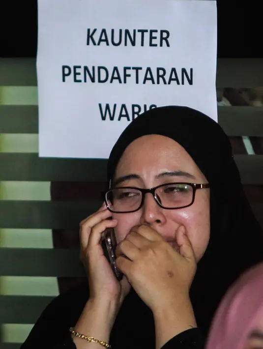 Ekspresi keluarga saat berada di dekat ruang forensik Rumah Sakit Kuala Lumpur menunggu  jenazah korban kebakaran sekolah agama Darul Quran Ittifaqiyah, Malaysia (14/9). (AFP Photo/Sadiq Asyraf)
