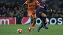 Aksi Bertrand Traore berduel dengan Ivan Rakitic pada leg kedua, babak 16 besar Liga Champions yang berlangsung di Stadion Camp Nou, Barcelona, Kamis (14/3). Barcelona menang 5-1 atas Lyon. (AFP/Lluis Gene)