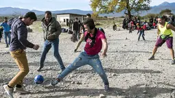 Imigran dan Pengungsi bermain bola sambil menunggu registrasi, sebelum melewati perbatasan Makedonia, Rabu (11/11/2015). AFP Photo/Robert Atanasovski).