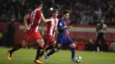 Bintang Barcelona, Lionel Messi, berusaha melewati bek Girona, Juanpe Ramirez, pada laga La Liga Spanyol di Stadion Montilivi, Girona, Sabtu (23/9/2017). Girona kalah 0-3 dari Barcelona. (AFP/Josep Lago)