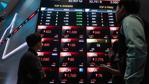 Orang-orang memperhatikan layar digital yang menampilkan pergerakan Indeks Harga Saham Gabungan (IHSG) di Bursa Efek Indonesia, Jakarta, Kamis (29/1/2026). Indeks Harga Saham Gabungan (IHSG) pada penutupan perdagangan Kamis (29/1/2026) ini berada di zona merah. (YASUYOSHI CHIBA/AFP)