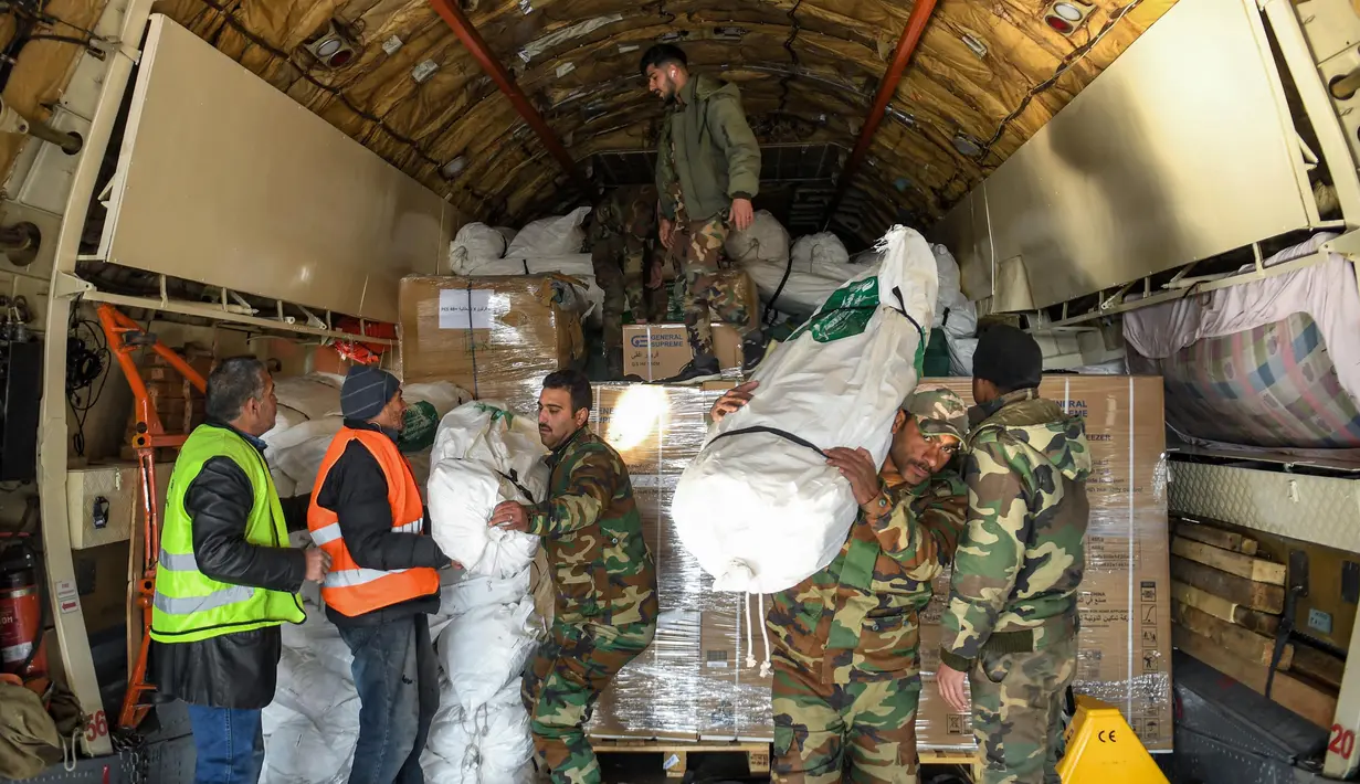 Personil gabungan setempat menurunkan paket bantuan kemanusiaan yang disediakan oleh Arab Saudi untuk para korban gempa bumi Turki dan Suriah diturunkan dari pesawat angkut Ilyushin Il-76TD di Bandara Internasional Aleppo, Suriah Utara, Selasa (14/2/2023). Jumlah korban gempa Turki dan Suriah terus bertambah. Banyak warga yang tinggal di zona bencana tidur di mobil mereka atau di jalan di bawah selimut dalam cuaca dingin yang membekukan. (AFP)