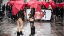 Sejumlah wanita pekerja seks menggenakan busana hitam dan topeng serta membawa payung merah berunjuk rasa di Skopje (17/12). Para pekerja seks ini memprotes kekerasan yang mereka alami, dan hukuman untuk klien prostitusi. (AFP Photo/Robert Atanasovski)