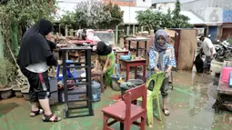 Guru bekerja bakti membersihkan fasilitas sekolah usai banjir menerjang gedung SD-SMP Perguruan Rakyat 2 di Kampung Melayu Kecil, Kelurahan Bukit Duri, Kecamatan Tebet, Jakarta Selatan, Senin (6/1/2020). (merdeka.com/Iqbal S. Nugroho)