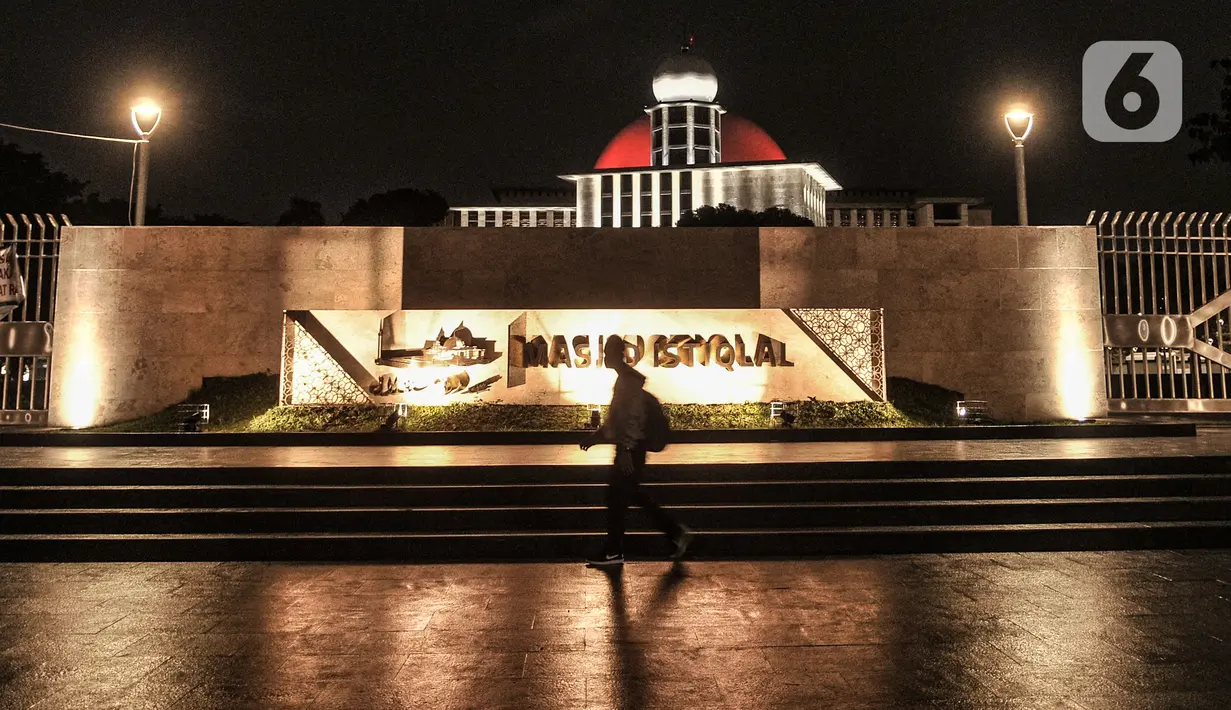 Pejalan kaki melintas di depan Masjid Istiqlal, Jakarta, Senin (22/2/2021). Wajah baru Masjid Istiqlal terasa lebih indah ketika menjelang malam dengan ornamen lampu yang menghiasi seluruh kompleks masjid. (merdeka.com/Iqbal S Nugroho)