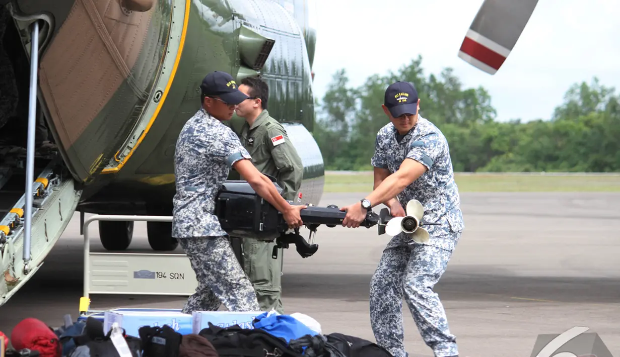 Militer Singapura membantu menurunkan barang bantuan dari pesawat, Pangkalan Bun, Kalteng, Kamis (1/1/2015). (Liputan6.com/Herman Zakharia)