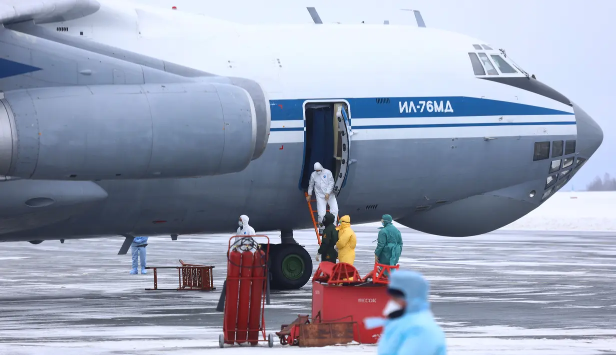 Petugas medis menyambut kedatangan warga yang turun dari pesawat militer di sebuah bandara luar Tyumen, Rusia, Rabu (5/2/2020). Rusia mengevakuasi 144 orang dari Wuhan yang terdiri dari warga Rusia, Belarus, Ukraina, dan Armenia menyusul wabah virus corona. (AP Photo/Maxim Slutsky)