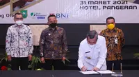 Ketua Gapki Riau Jatmiko K Santosa mendampingi Gubernur Riau Syamsuar menandatangani MoU pembangunan rumah bagi buruh sawit. (Liputan6.com/M Syukur)