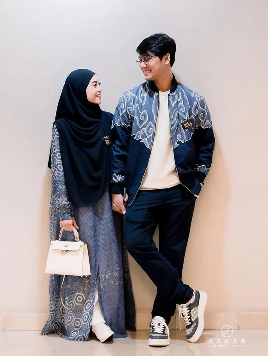 Serasi dengan Rizky Billar, Lesti Kejora mengenakan gamis biru motif parang dipadukan kerudung panjang navy. Sambil membawa tas putih serasi dengan sepatunya. [@lestykejora]