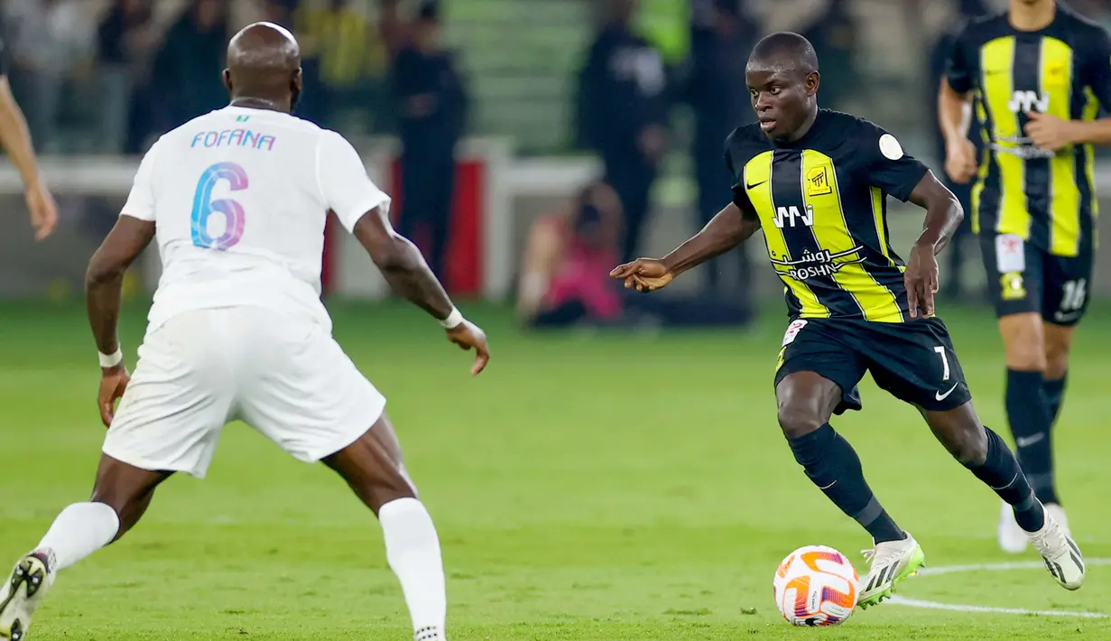 Pemain Al Ittihad, N'Golo Kante, berusaha melewati pemain Al Nassr, Seko Fofana, dalam laga tunda pekan ke-17 Liga Arab Saudi di King Abdullah Sport City Stadium, Jeddah, Rabu (27/12/2023). (Photo by AFP)