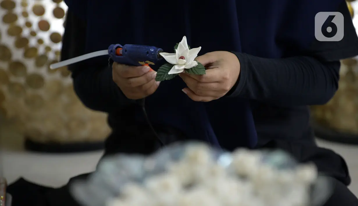 Perajin menyelesaikan pembuatan kerajinan tangan dari kulit kerang di Pamulang 2, Tangerang Selatan, Banten, Senin (20/7/2020). Kerajinan tangan unik untuk hiasan rumah dijual dengan harga Rp 10 ribu hingga Rp 5 juta. (merdeka.com/Dwi Narwoko)