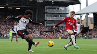 Gelandang Fulham, Willian, melepaskan tendangan saat dikawal saat menghadapi Manchester United pada laga pekan ke-11 Premier League 2023/2024 yang digelar di Craven Cottage, Sabtu (4/11/2023) malam WIB. (AFP/Adrian Dennis)