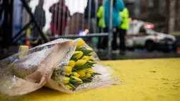Seikat bunga diletakan di garis finish Boston Marathon pada peringatan setahun terjadinya Bom Boston, Selasa (15/4/14) (AFP/Andrew Burton)