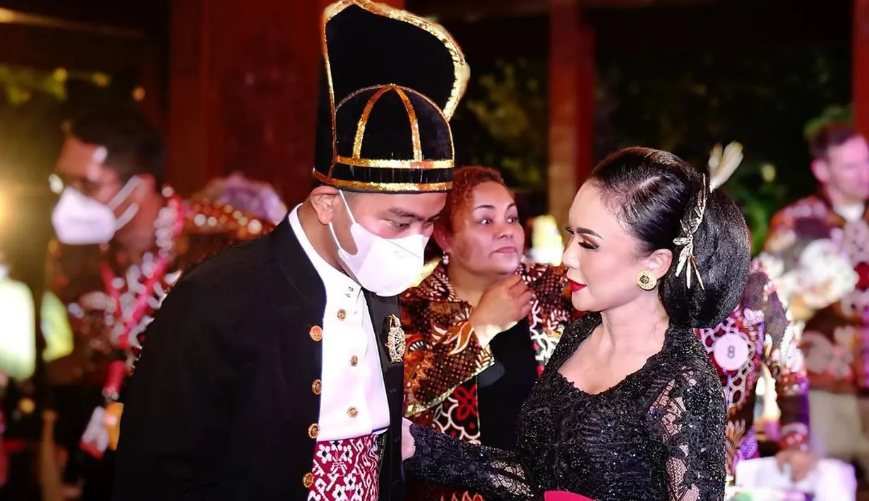 Dalam acara itu, Yuni Shara tampil anggun dengan kebaya hitam dari brokat lengkap dengan sanggul besar. Lipstik merah menyala membuat riasannya makin paripurna. Berbincang dengan Gibran yang berkemeja putih dilapisi beskap, belangkon, dan setagen merah, Yuni Shara tampak membahas sesuatu sambil memegang lengan Sang Wali Kota. (Foto: Dok. Instagram @yunishara36)