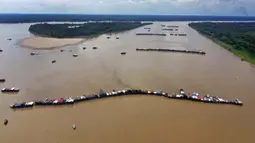 Tongkang pengerukan yang dioperasikan penambang ilegal berkumpul di anak Sungai Amazon, Sungai Madeira, di Autazes, Amazonas, Brasil, 25 November 2021. Para pencinta lingkungan membunyikan alarm tentang konvergensi perahu yang belum pernah terjadi sebelumnya. (AP Photo/Edmar Barros)