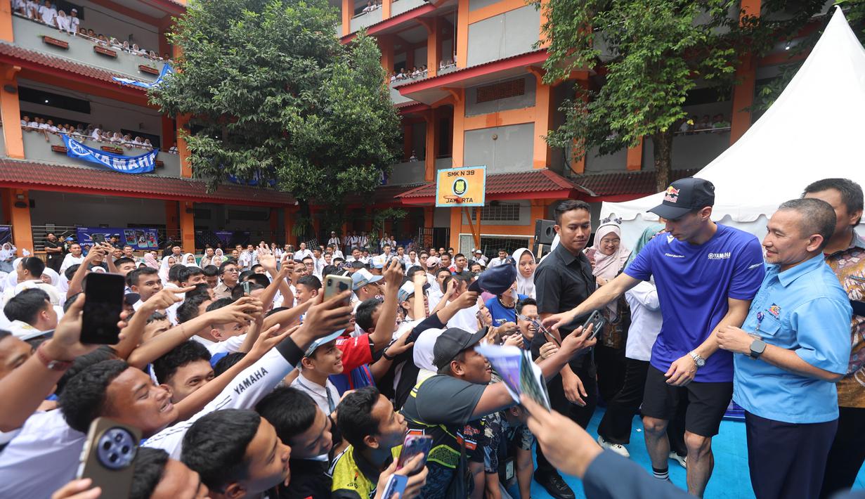 Kehadiran Toprak Razgatlioglu mendapat sambutan hangat dan meriah dari ratusan siswa-siswi SMKN 39 Jakarta. Tampak dalam foto, pembalap rookie Prima Pramac Racing, Toprak Razgatlioglu saat menyapa siswa/siswi SMK Negeri 39 di kawasan Cempaka Putih, Jakarta Pusat, Selasa (20/1/2026). (Bola.com/M Iqbal Ichsan)