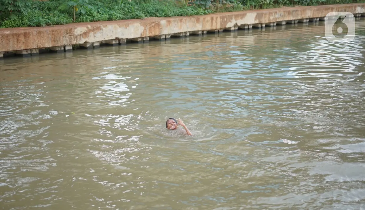 Seorang anak berenang di aliran Sungai Kalimalang, Jakarta, Selasa (18/8/2020). Keterbatasan ekonomi menyebabkan anak-anak tersebut memanfaatkan Sungai Kalimalang sebagai tempat berenang, meskipun berbahaya bagi keselamatan dan kesehatan mereka. (Liputan6.com/Immanuel Antonius)
