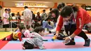 Sejumlah ibu menarik perhatian anaknya untuk mencapai garis finis saat mengikuti kompetisi 'Bayi Merangkak',  Yokohama, Jepang, Senin (23/11/2015). Tingkah bayi yang lucu menjadi pemandangan yang menggemaskan bagi para penonton. (AFP Photo/Kazuhiro Nogi)