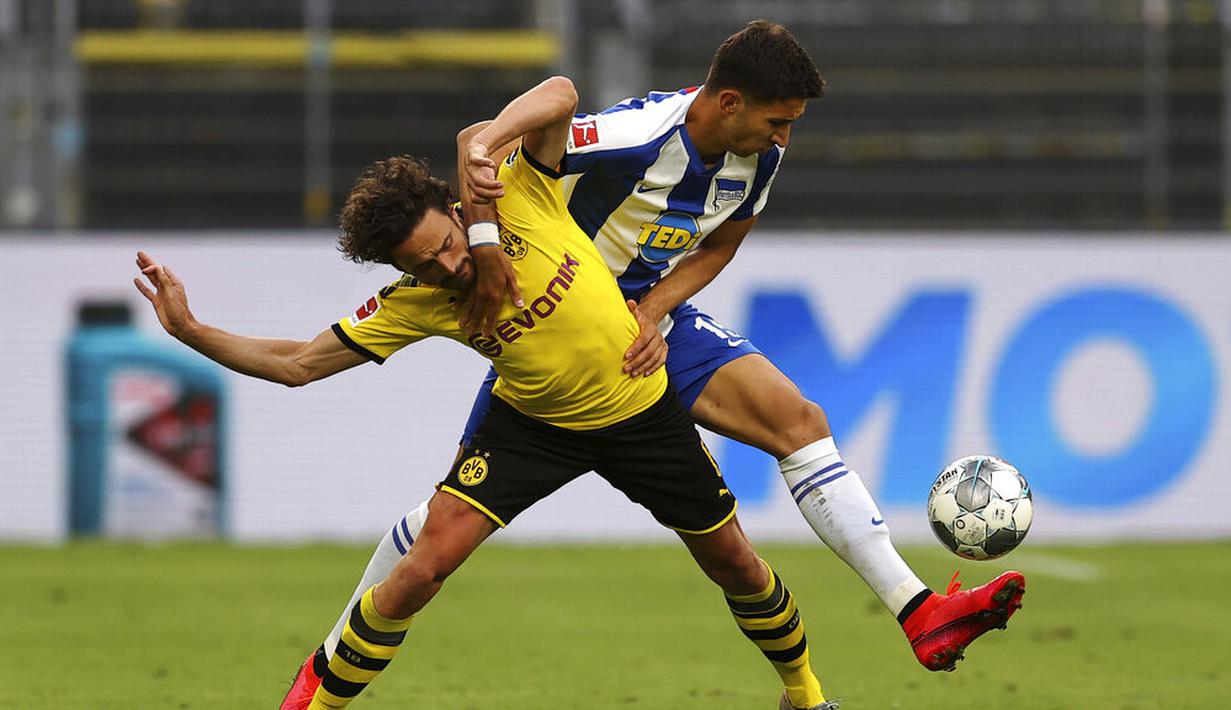 Pemain Borussia Dortmund, Thomas Delaney, berebut bola dengan pemain Hertha Berlin, Marko Grujic, pada laga Bundesliga di Stadion di Signal Iduna Park, Sabtu (6/6/2020). Borussia Dortmund menang 1-0 atas Hertha Berlin. (AP/Lars Baron)