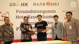 Direktur Bisnis Bank DKI,  Antonius Widodo Mulyono (kedua kiri) dan CMO Go-Jek,  Piotr Jakubowski (tengah) usai MoU antara Bank DKI dengan Gojek Indonesia, Selasa (7/11). (Liputan6.com/Pool/Budi)