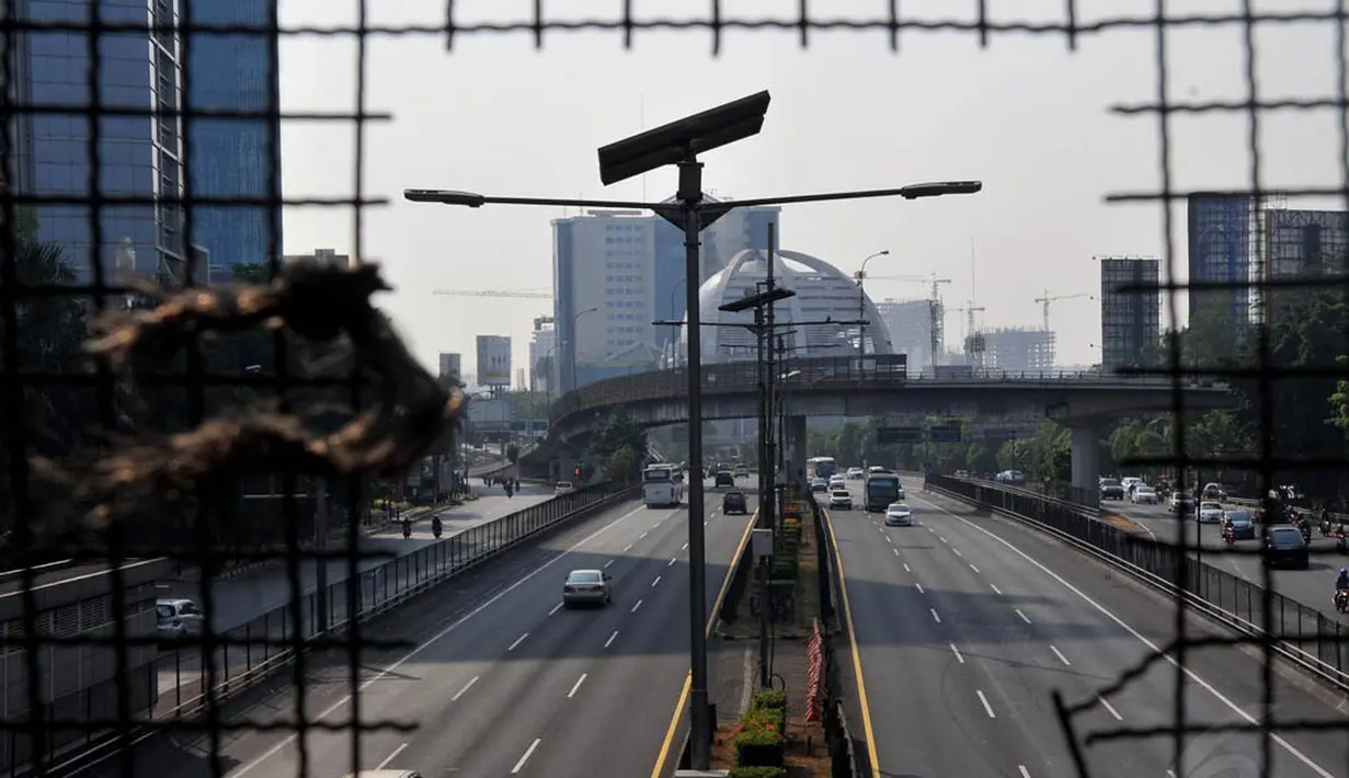 Kendaraan melintasi kawasan Jalan MH Thamrin, Jakarta, Minggu (5/10/14). (Liputan6.com/Johan Tallo)