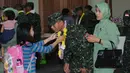 Seorang anak mengalungkan bunga kepada sang ayah usai usai penyambutan kedatangan kontingen AASAM di Bandara Soetta, Banten, Senin (23/5/2016). TNI AD menjadi juara umum AASAM 2016 yang digelar di Australia. (Liputan6.com/Helmi Fithriansyah)