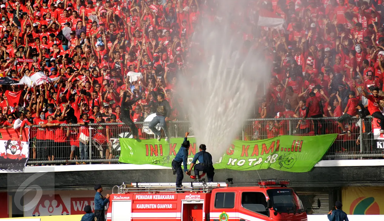 Petugas pemadam menyemprotkan air untuk mendinginkan suasana Stadion I Wayan Dipta, Gianyar, Bali, Minggu (30/8/2015). Jelang pembukaan turnamen Piala Presiden 2015, ribuan suporter menyerbu stadion Dipta, Gianyar, Bali. (Liputan6.com/Helmi Fithriansyah) 