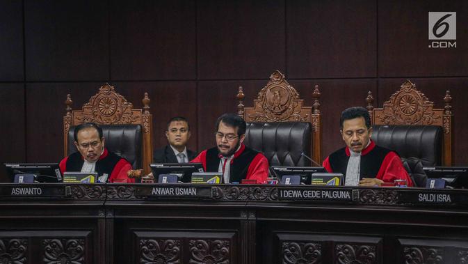 Ketua Majelis Hakim Konstitusi Anwar Usman (tengah) saat membacakan putusan MK di Gedung MK, Jakarta, Kamis (27/6/2019). MK menolak seluruh gugatan hasil Pilpres 2019 yang diajukan Prabowo Subianto-Sandiaga Uno yang disepakati sembilan hakim konstitusi. (Liputan6.com/Faizal Fanani)