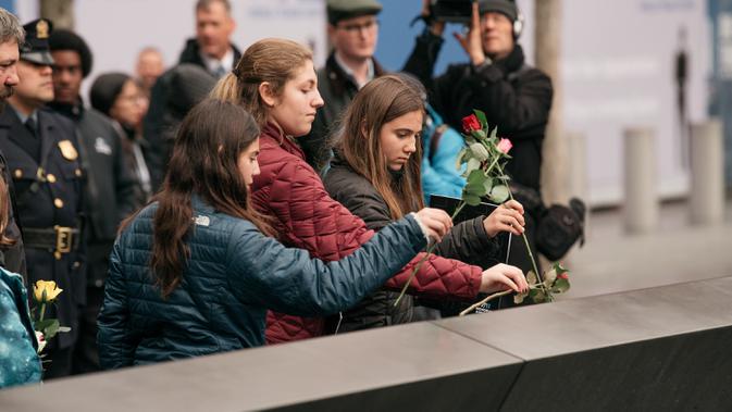Kerabat meletakkan mawar di atas plakat bertuliskan nama-nama korban pengeboman World Trade Center 1993 pada upacara peringatan 