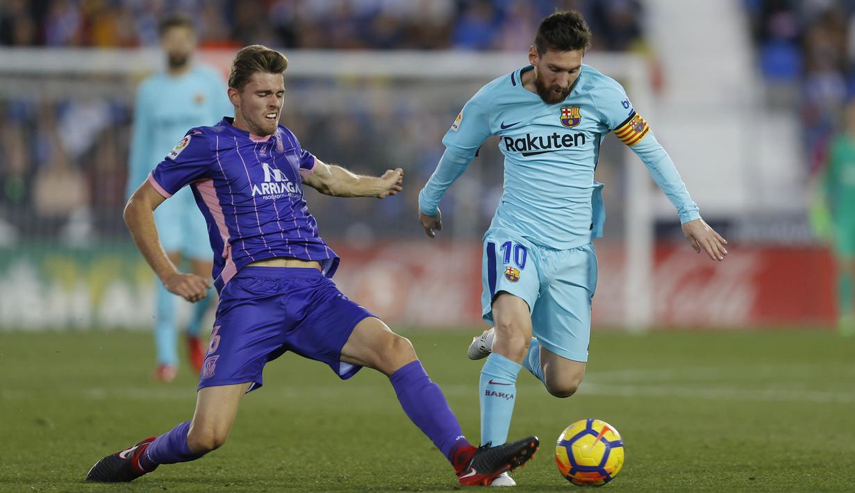Bintang Barcelona, Lionel Messi, berusaha melewati gelandang Leganes, Gerard Gumbau, pada laga La Liga Spanyol di Stadion Butarque, Leganes, Sabtu (18/11/2017). Leganes kalah 0-3 dari Barcelona. (AP/Francisco Seco)