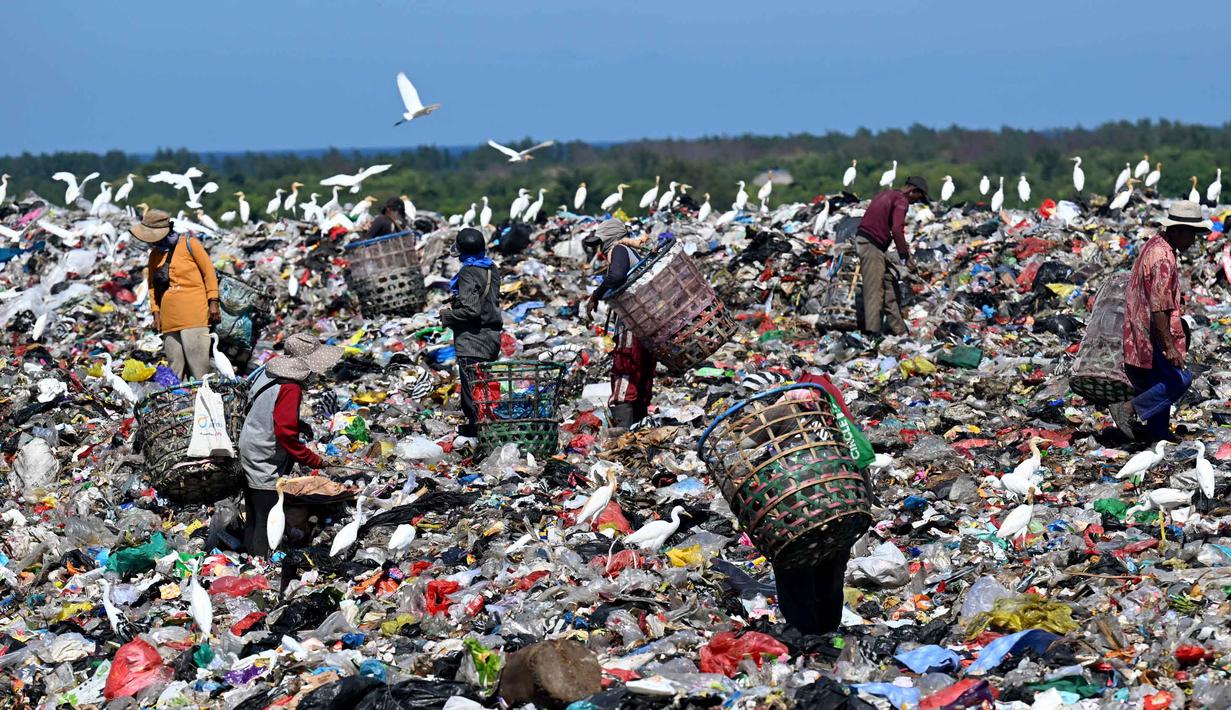 Untuk diketahui, sejak 1 April 2026, TPA Suwung hanya menerima sampah residu dan anorganik, sementara sampah organik dilarang masuk. Tampak dalam foto, orang-orang mengumpulkan sampah di Tempat Pembuangan Akhir (TPA) Suwung, Denpasar, Bali, pada Jumat 17 April 2026. (SONNY TUMBELAKA/AFP)